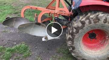 Compact tractor plowing with a 2 bottom plow