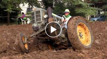 Old tractors plowing full power in mud 
